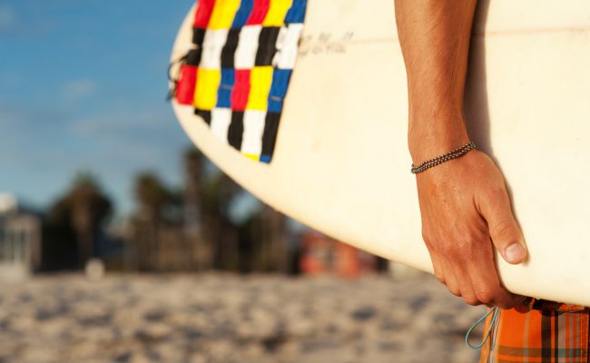 closeup of a surfer holding a surfboard